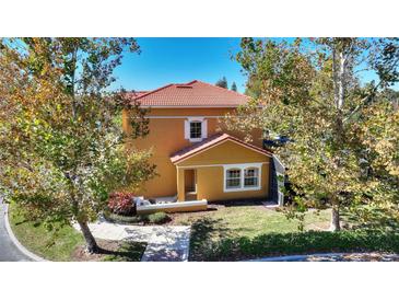 Attractive 2 story home with orange exterior and landscaped grounds at 4763 Vero Beach Pl, Kissimmee, FL 34746