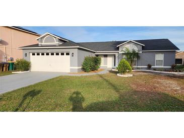 House exterior featuring a two-car garage and well-maintained lawn at 552 Brentford Ct, Kissimmee, FL 34758