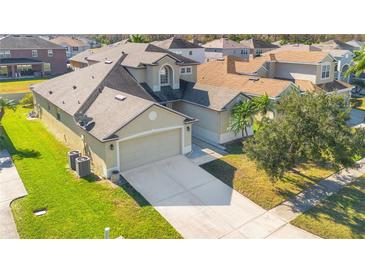 Two-story house with a large driveway and well-manicured lawn, located in a residential neighborhood at 3571 Maple Ridge Loop, Kissimmee, FL 34741