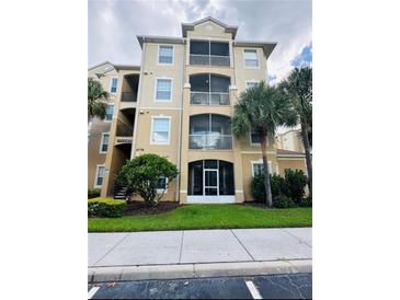 Three-story condo building with palm trees and ample parking at 2778 Almaton Loop # 303, Kissimmee, FL 34747
