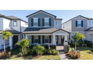Two-story house with gray siding, landscaping, and a walkway at 12749 Brodlove Lane, Winter Garden, FL 34787