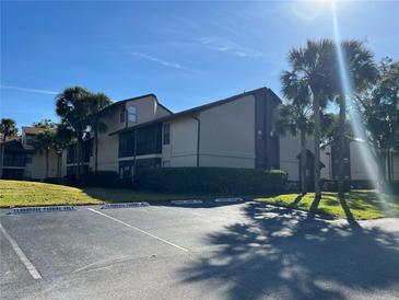 Exterior view of condo building with parking and landscaping at 3036 S Semoran Blvd # S, Orlando, FL 32822