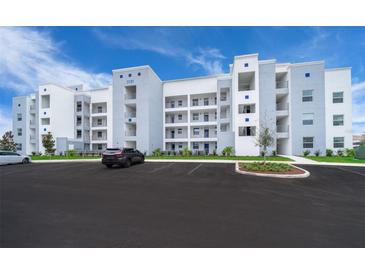 Modern condo building with ample parking and landscaped grounds at 3150 Paradox Cir # 208, Kissimmee, FL 34746