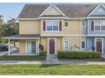 Two-story townhome with covered entry,red door, and landscaped yard at 4012 Santa Maria # 101, Kissimmee, FL 34741