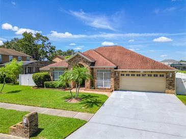 Brick house with a two-car garage and palm trees in the front yard at 1918 Crosshair Cir, Orlando, FL 32837