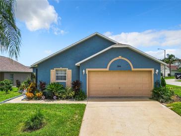 Charming one-story home with a two-car garage and well-maintained landscaping at 204 Fox Loop, Davenport, FL 33837
