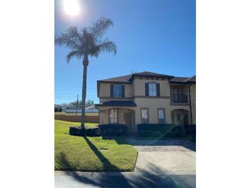 Two-story townhome with attractive landscaping and a paved driveway at 467 La Mirage St, Davenport, FL 33897