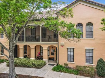 Front view of charming two-story townhome with arched entryways and balconies at 504 Mirasol Cir # 204, Celebration, FL 34747