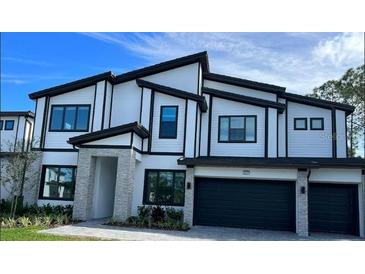 Two-story modern home with gray stone accents and a two-car garage at 1447 Butterfly, Davenport, FL 33837