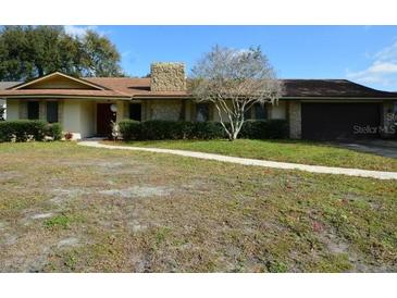 Ranch style home with attached garage and landscaped lawn at 5113 Gramont Ave, Belle Isle, FL 32812