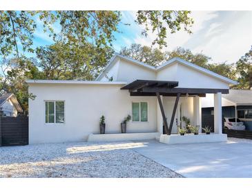 Modern white house with dark wood accents and a gravel driveway at 803 E 11Th Ave, New Smyrna Beach, FL 32169