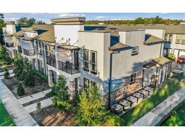 Modern townhome with gray exterior, balconies, and landscaping at 1800 Houston St, Kissimmee, FL 34743
