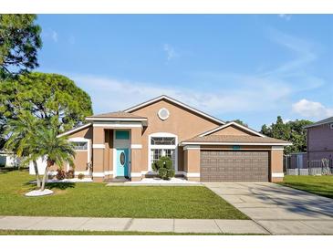 Attractive one-story home with a teal door and landscaped yard at 2303 Merrimack Dr, Kissimmee, FL 34743