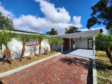 Front view of a single-story home with a covered carport and brick driveway at 1427 Wilton Ave, Orlando, FL 32805