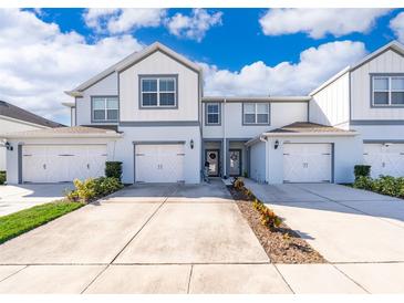 Charming two-story townhome with white siding, attached garage, and landscaped front yard at 3896 Grassland Dr, Orlando, FL 32824