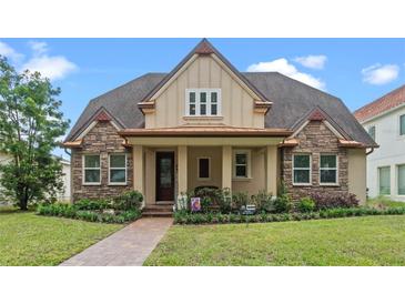 Charming two-story home with stone and siding exterior, covered porch, and landscaped yard at 3305 Cat Brier Trl, Harmony, FL 34773
