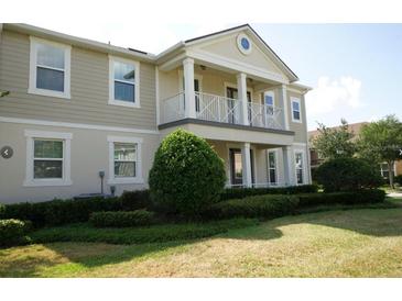 Two-story house with balcony, columns, and well-maintained landscaping at 2900 Windmill Dr, Kissimmee, FL 34741