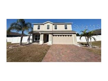 Two-story house with a brick driveway and a landscaped lawn at 640 Spanish Pine Rd, Davenport, FL 33837