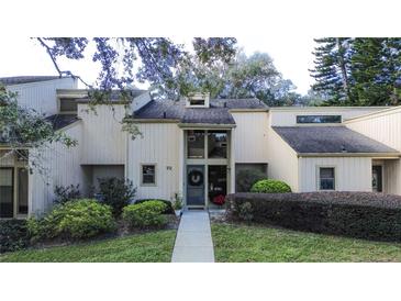 Tan two-story townhouse with a landscaped yard and walkway at 72 Aspen Dr, Haines City, FL 33844