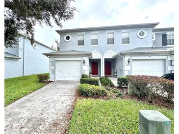 Front view of two-story townhome with double garage at 10786 Savannah Wood Dr, Orlando, FL 32832