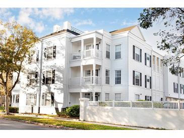 White three-story building with black shutters and white picket fence at 453 Water St, Kissimmee, FL 34747