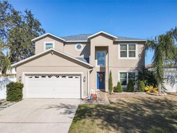 Two-story house with a neutral exterior, a three-car garage, and palm trees at 513 Big Black Way, Kissimmee, FL 34759