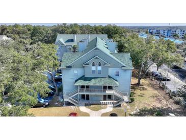 Aerial view of a light blue multi-unit building with green roof at 5980 Westgate Dr # Apt 103, Orlando, FL 32835