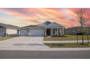 Two-story house with two-car garage, landscaped yard, and sunset in background at 2937 Hooded Crane Cv, Harmony, FL 34773