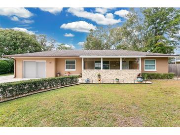 Single-story home with landscaped lawn, screened porch and attached garage at 310 Florida Ave, Saint Cloud, FL 34769