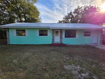 Charming single-story home with a teal exterior and a stone accent at 1420 Ne 22Nd St, Ocala, FL 34470