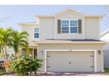 Two-story house with light beige siding, a two-car garage, and landscaping at 3112 Armstrong Spring Dr, Kissimmee, FL 34744