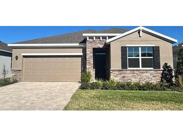 Tan two-story house with stone accents and a two-car garage at 4923 Nw 39Th Loop, Ocala, FL 34482