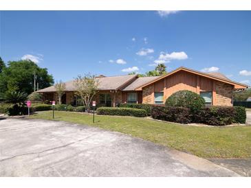 Ranch-style home with mature landscaping and circular driveway at 8723 A D Mims Rd, Orlando, FL 32818