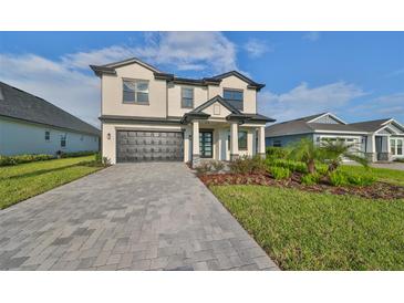 Two-story home with a gray brick driveway at 485 Adams View Ln, Auburndale, FL 33823