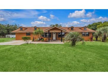 One-story home with brown exterior and a well-maintained lawn at 22134 Obrien Rd, Howey In The Hills, FL 34737