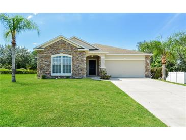 Charming one-story house with stone accents and a grassy yard at 31817 Sunpark Cir, Leesburg, FL 34748
