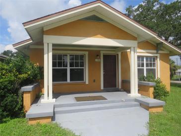 House exterior featuring a yellow facade, covered porch, and steps at 1196 N Florence Ave, Lakeland, FL 33805