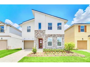 Two-story home with modern design and stone accents at 1959 Tropical Palms Cir, Kissimmee, FL 34747