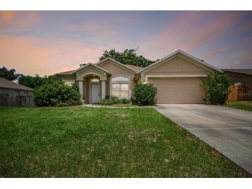 One-story house with a tan exterior and a two-car garage at 1561 E Merrick Dr, Deltona, FL 32738