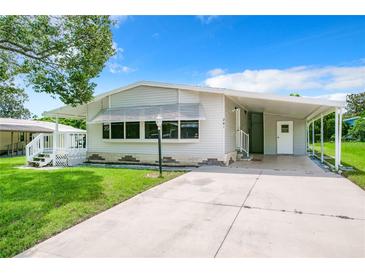 Mobile home exterior with carport and landscaping at 241 Menlo Park Ave, Davenport, FL 33897