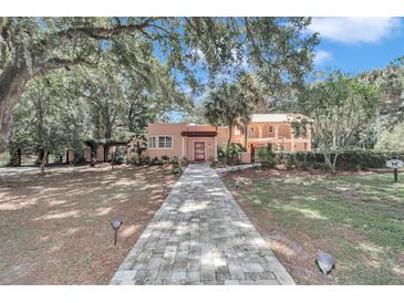 Spanish style home with brick walkway and lush landscaping at 8901 Nw 136Th Avenue Rd, Ocala, FL 34482