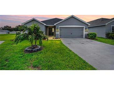 Gray house with a two-car garage and landscaped lawn at 6388 Gardner Dr, Lakeland, FL 33813