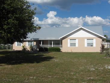 Single-story home with metal roof, light beige stucco, and white trim at 6638 Hatcher Rd, Lakeland, FL 33811