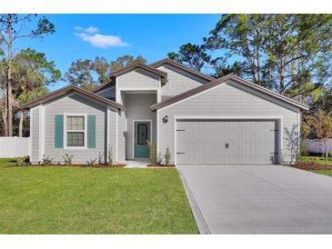 Charming house exterior with a two-car garage and green accents at 17691 Sw 36Th Avenue Rd, Ocala, FL 34473