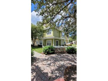 Two-story light green house with white fence at 4000 Santa Maria Dr # 108, Kissimmee, FL 34741