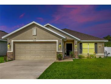 House exterior featuring a two-car garage and well-manicured lawn at 4448 Nw 2Nd Ct, Ocala, FL 34475