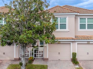 Two-story townhome with attached garage and landscaping at 8311 Foster Dr, Davenport, FL 33896