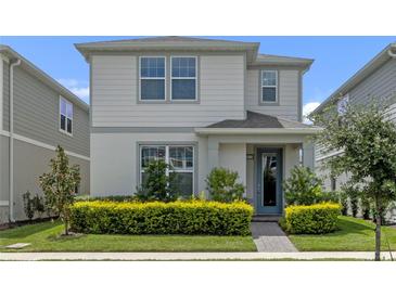 Two-story house with gray siding, a light gray door, and landscaping at 14234 Lanikai Beach Dr, Orlando, FL 32827