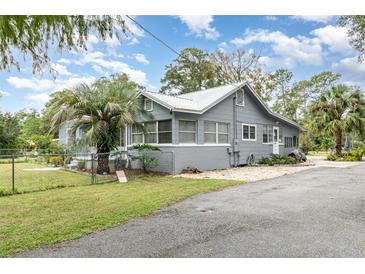 Gray house with metal roof, driveway, and fenced yard at 323 Nw 25Th St, Ocala, FL 34475