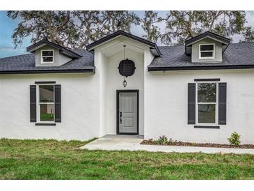 Modern home exterior with gray door and black shutters at 225 Diesel Rd, Mulberry, FL 33860